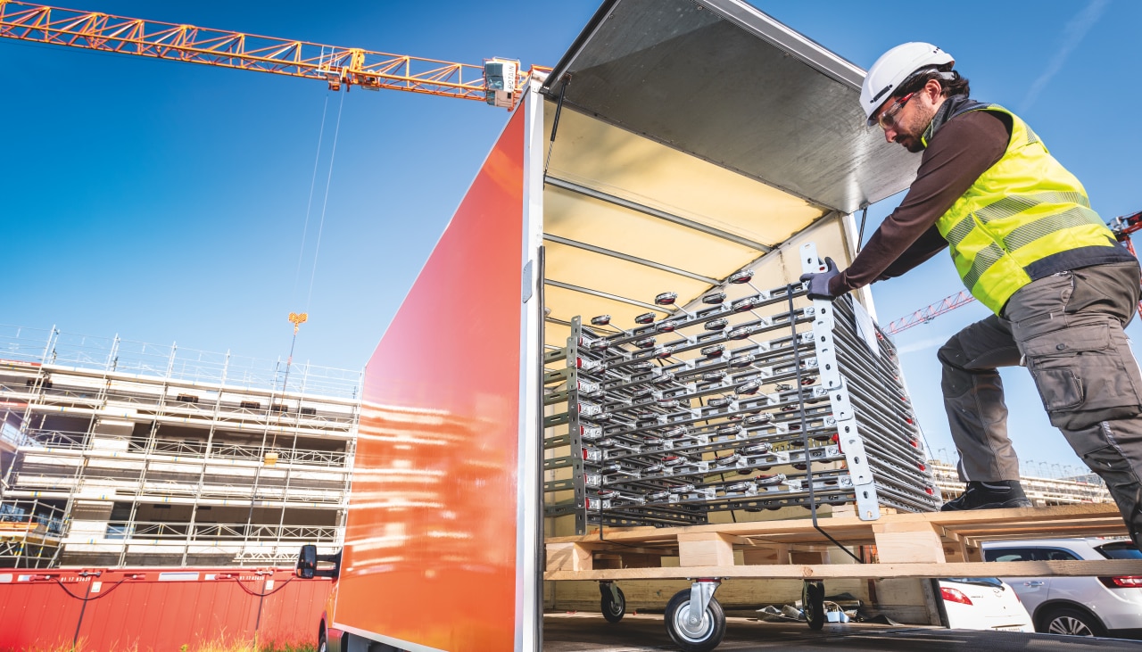 Worker unloading prefabricated modular support modules from a truck